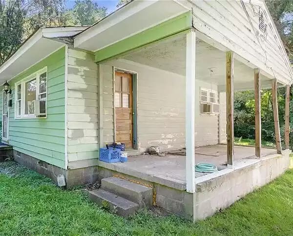 Small green cape style home requiring porch, siding and foundation repairs sold quickly in West Creek.